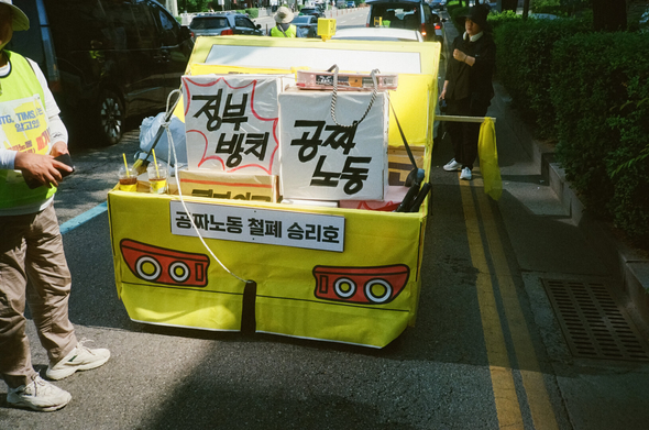 택시지부 조합원들이 대행진동안 끌고 갈 노란색 택시 모형. 트렁크 부분에 "정부방치", "공짜노동"과 같은 상징물이 실려있다. 택시 모형 번호판 자리에는 "공짜노동 철폐 승리호"라는 이름이 붙어있다.