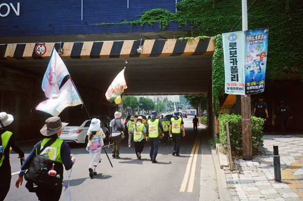 다리 아래로 걸어들어가는 행진대오.